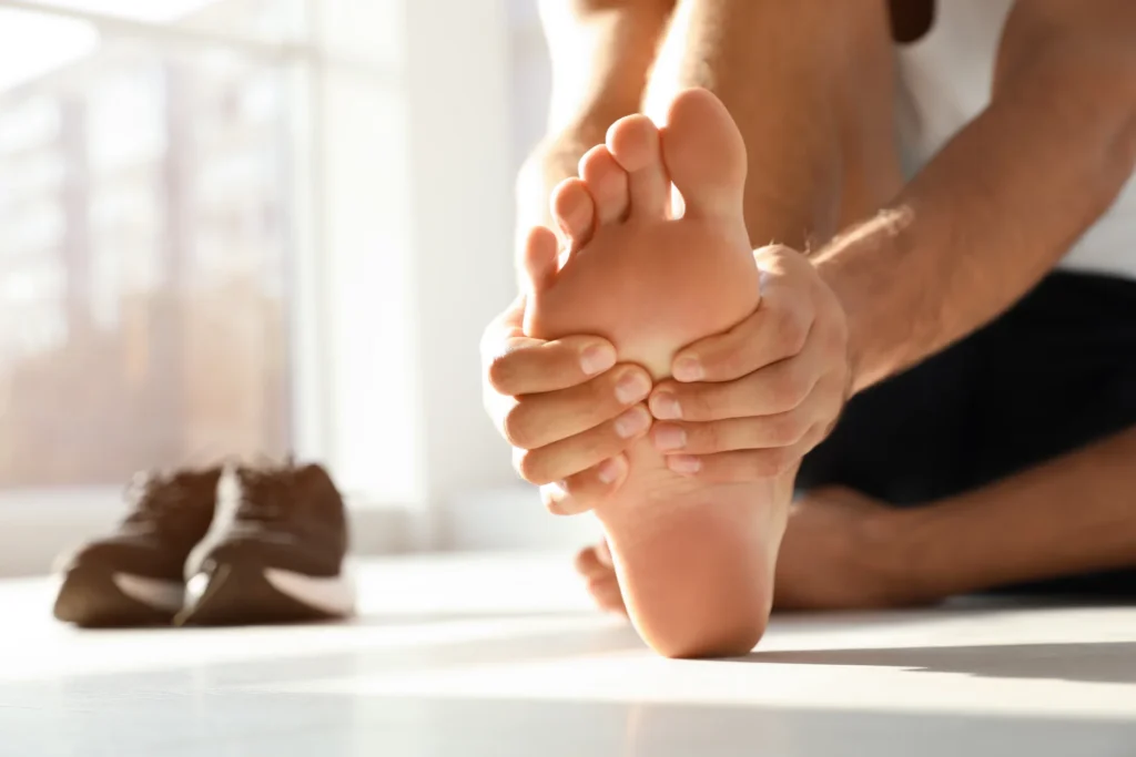 adult massaging foot in bright home setting 2026 03 27 01 45 12 utc