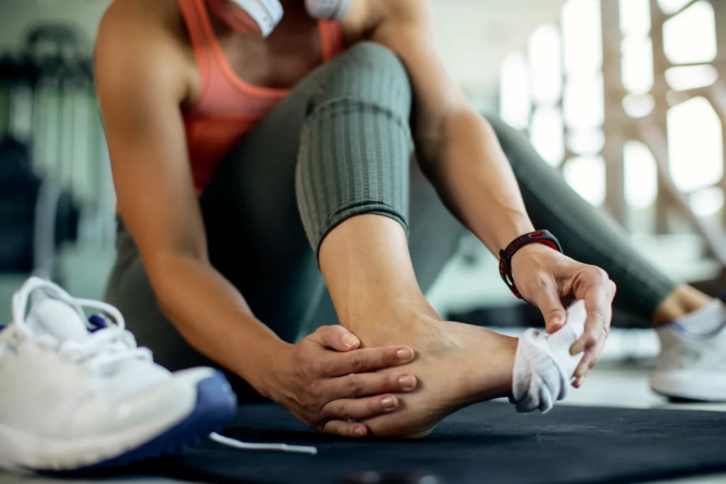 closeup athletic woman injured her foot workout gym