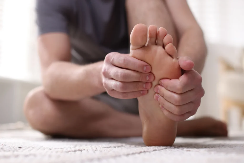 man massaging his foot while seated 2026 03 20 04 14 32 utc