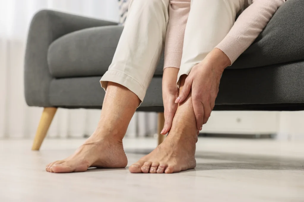 woman seated massaging foot indoors in natural li 2026 04 23 01 49 01 utc